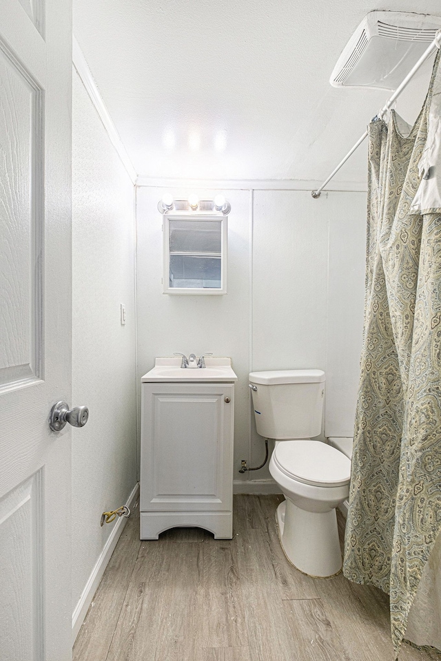 bathroom featuring toilet, a shower with curtain, vanity, and wood finished floors