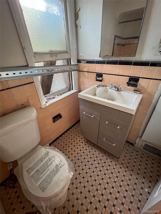 3945 Devonshire Rd, Detroit, MI 48224 - bathroom featuring tile walls, toilet, and vanity