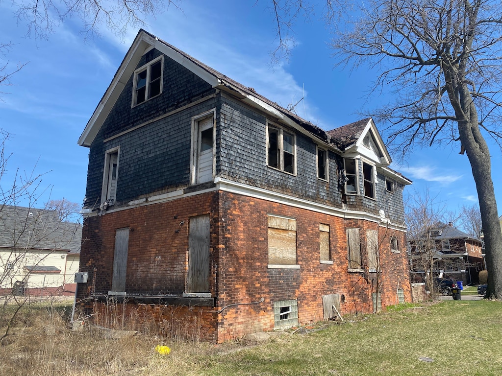 view of home's exterior featuring brick siding and a lawn