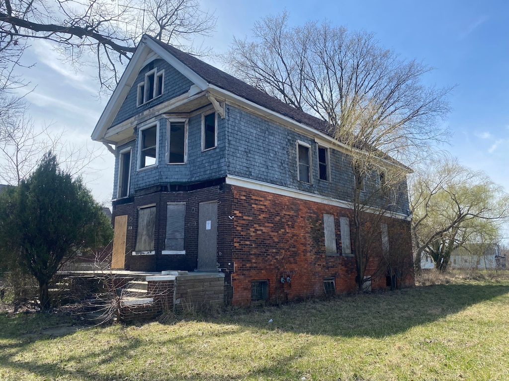 view of home's exterior with a lawn and brick siding