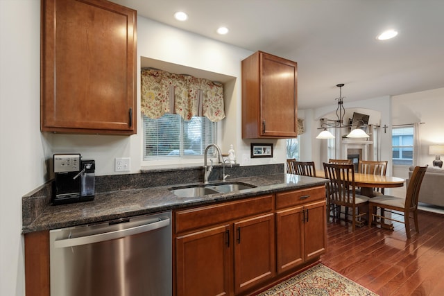 kitchen featuring a wealth of natural light, dark wood finished floors, stainless steel dishwasher, and a sink