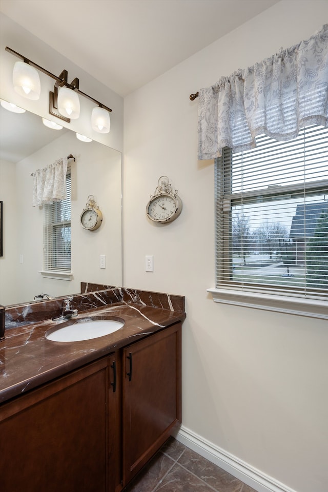 bathroom with vanity, a wealth of natural light, and baseboards