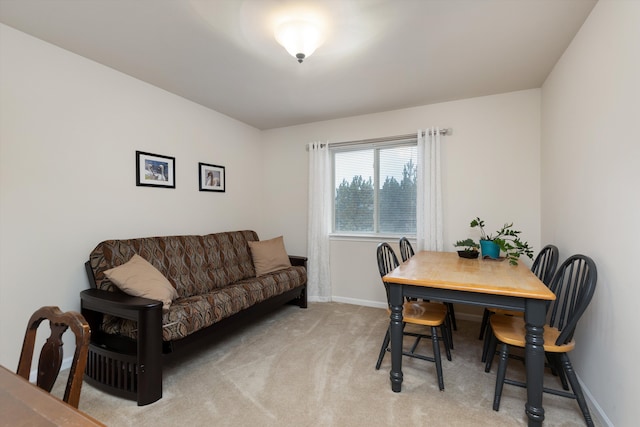 dining space featuring light colored carpet and baseboards