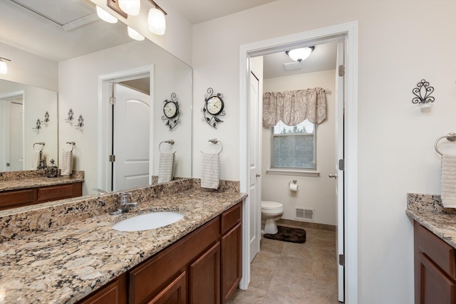 full bathroom featuring toilet, baseboards, visible vents, a sink, and two vanities
