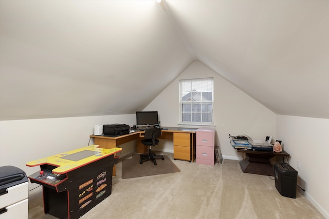 home office featuring lofted ceiling, baseboards, and light colored carpet