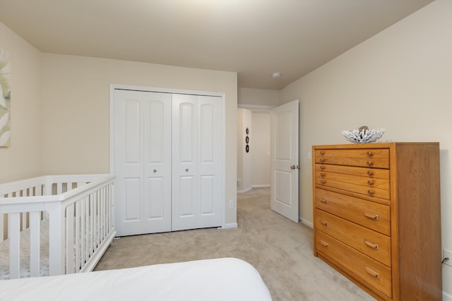 bedroom featuring light carpet, a closet, and baseboards