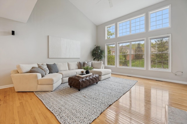 45055 Walnut Rdg, Northville, MI 48168 - living room with high vaulted ceiling, baseboards, light wood finished floors, and ceiling fan