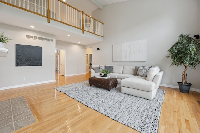 45055 Walnut Rdg, Northville, MI 48168 - living area featuring wood finished floors, a towering ceiling, baseboards, beam ceiling, and recessed lighting