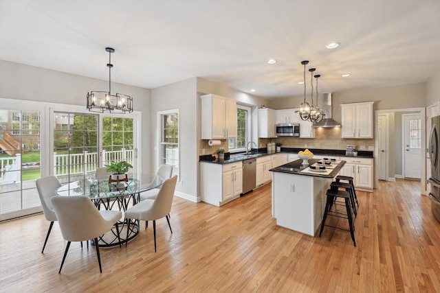 45055 Walnut Rdg, Northville, MI 48168 - kitchen with a chandelier, appliances with stainless steel finishes, wall chimney exhaust hood, a sink, and recessed lighting