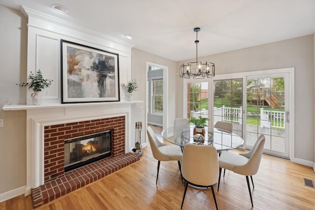 45055 Walnut Rdg, Northville, MI 48168 - dining room with baseboards, wood finished floors, a chandelier, and a fireplace