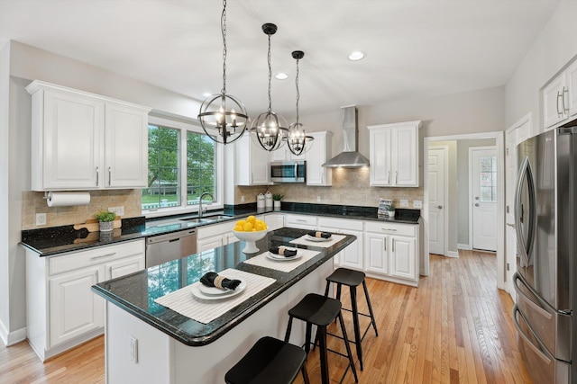 45055 Walnut Rdg, Northville, MI 48168 - kitchen featuring appliances with stainless steel finishes, wall chimney exhaust hood, a sink, a chandelier, and white cabinetry
