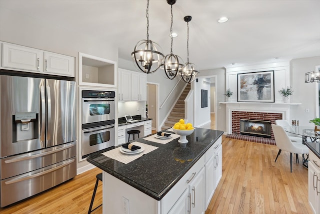 45055 Walnut Rdg, Northville, MI 48168 - kitchen with appliances with stainless steel finishes, a chandelier, white cabinetry, and a kitchen island