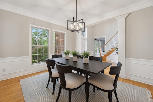 45055 Walnut Rdg, Northville, MI 48168 - dining space featuring a chandelier, wainscoting, light wood-type flooring, ornamental molding, and stairs