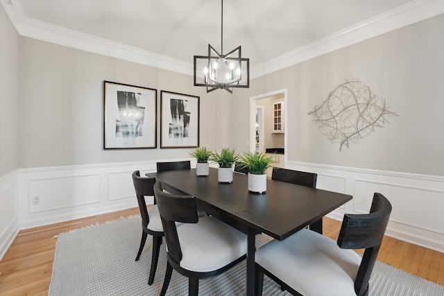 45055 Walnut Rdg, Northville, MI 48168 - dining space featuring a chandelier, ornamental molding, light wood-style flooring, wainscoting, and a decorative wall