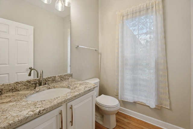 45055 Walnut Rdg, Northville, MI 48168 - bathroom with wood finished floors, baseboards, toilet, vanity, and plenty of natural light