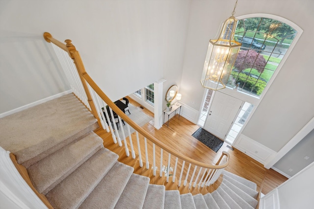 45055 Walnut Rdg, Northville, MI 48168 - entryway featuring a towering ceiling, stairway, wood finished floors, a chandelier, and baseboards