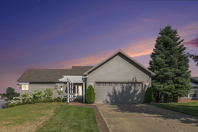 ranch-style home with a lawn, an attached garage, and concrete driveway