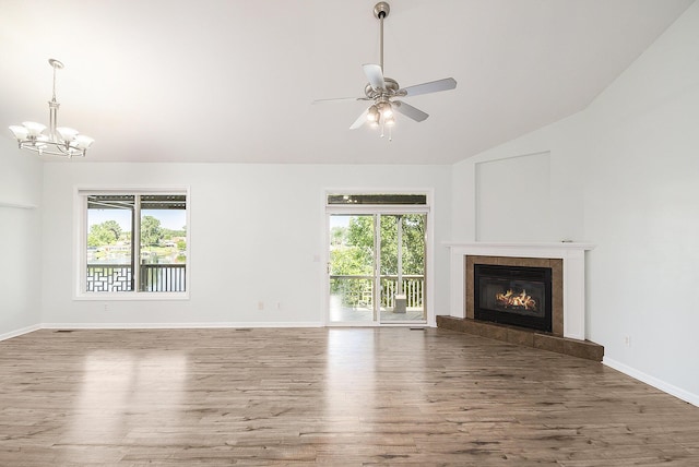 unfurnished living room with a tiled fireplace, plenty of natural light, and wood finished floors