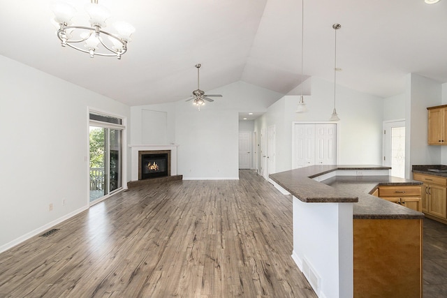 unfurnished living room with wood finished floors, a glass covered fireplace, baseboards, ceiling fan with notable chandelier, and visible vents