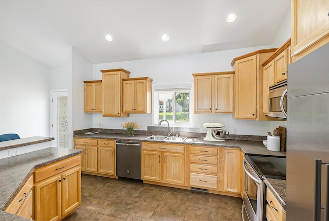 kitchen featuring light brown cabinets, a sink, dark countertops, and appliances with stainless steel finishes
