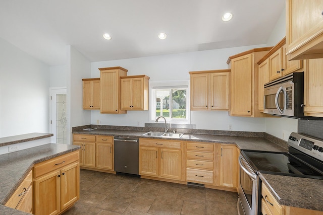 kitchen featuring a sink, light brown cabinetry, dark countertops, and appliances with stainless steel finishes