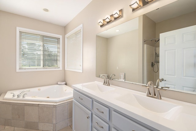 bathroom with a tub with jets, double vanity, a shower, and a sink