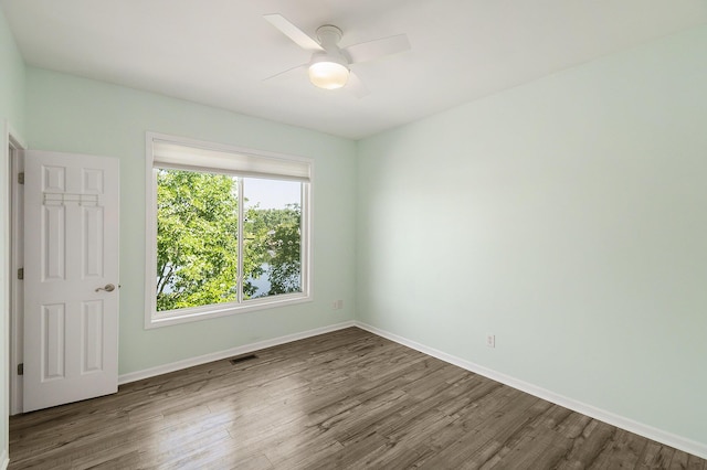 unfurnished room with visible vents, baseboards, ceiling fan, and wood finished floors