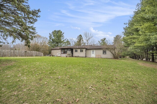 exterior space with fence and a lawn