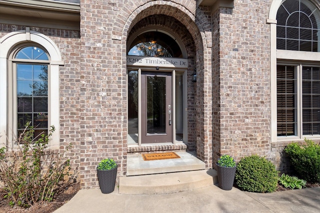 entrance to property featuring brick siding