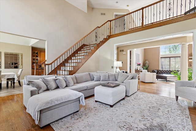 living room with a high ceiling, wood finished floors, and stairway