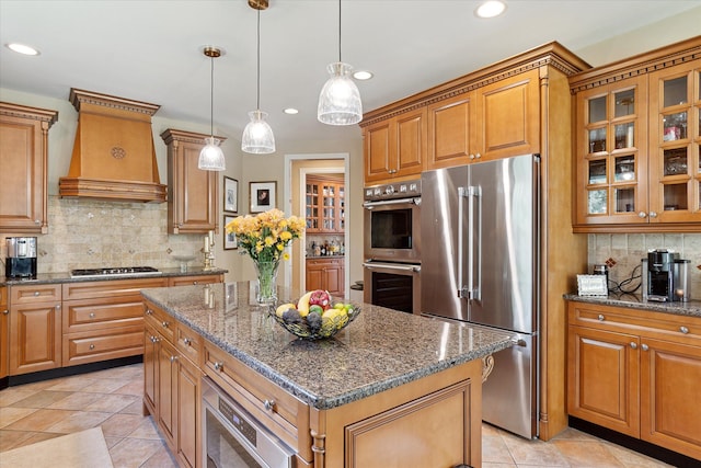 kitchen with a kitchen island, brown cabinets, and appliances with stainless steel finishes