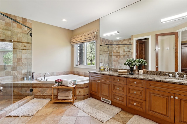 bathroom with visible vents, a sink, a bath, and a stall shower