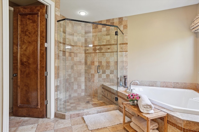 bathroom with a shower stall and a garden tub