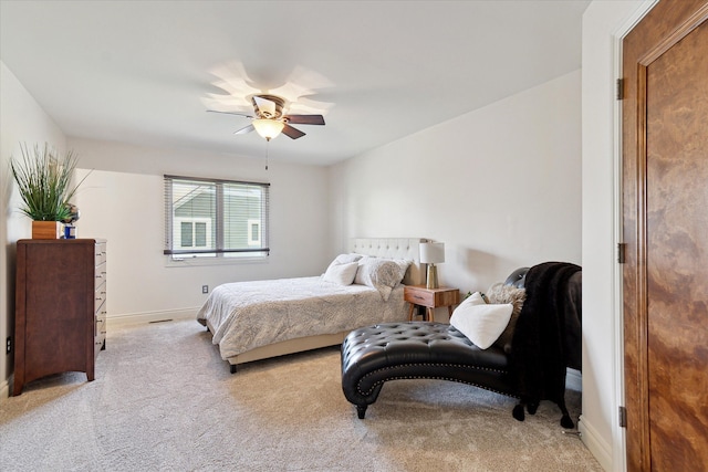 bedroom with baseboards, a ceiling fan, and light carpet