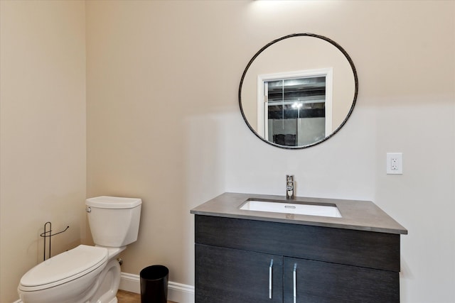 bathroom featuring vanity, baseboards, and toilet