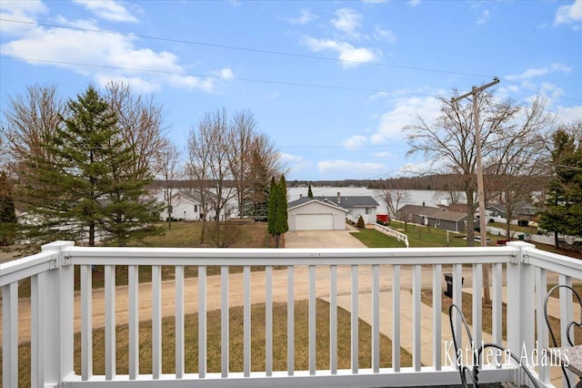 14319 Park Dr, Mecosta, MI 49332 - wooden terrace with a garage, a residential view, concrete driveway, and a lawn