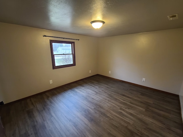 4161 Maple St, Brown City, MI 48416 - spare room featuring dark wood-type flooring, baseboards, and a textured ceiling