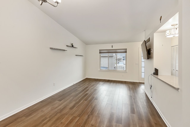unfurnished living room featuring dark wood-style flooring, visible vents, baseboards, and lofted ceiling