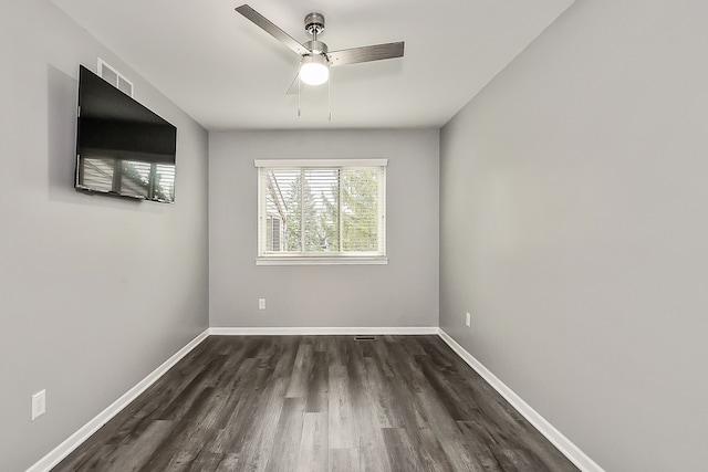 unfurnished room featuring dark wood-style flooring, baseboards, a ceiling fan, and visible vents