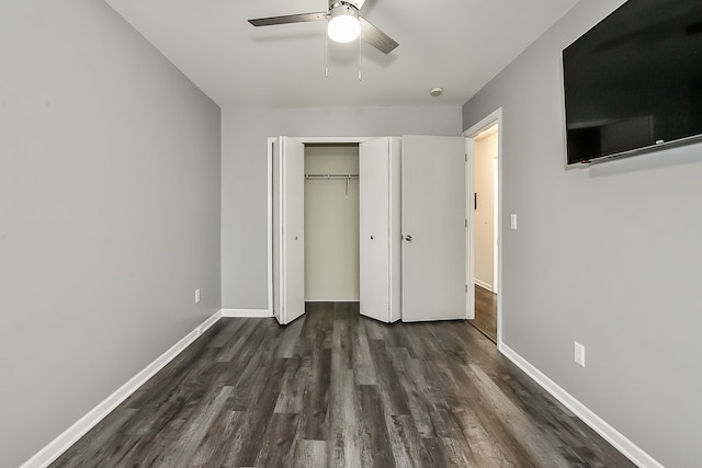 unfurnished bedroom with a ceiling fan, a closet, baseboards, and dark wood-style floors