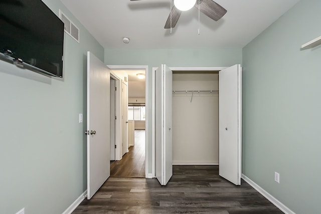 unfurnished bedroom with visible vents, baseboards, a closet, dark wood-style flooring, and a ceiling fan