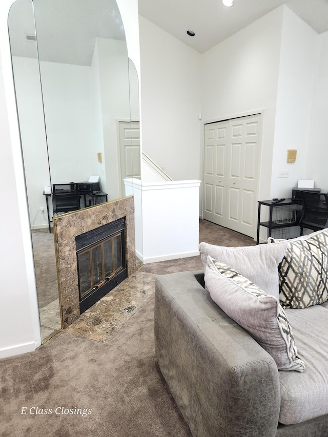living area with arched walkways, carpet floors, a towering ceiling, baseboards, and a fireplace