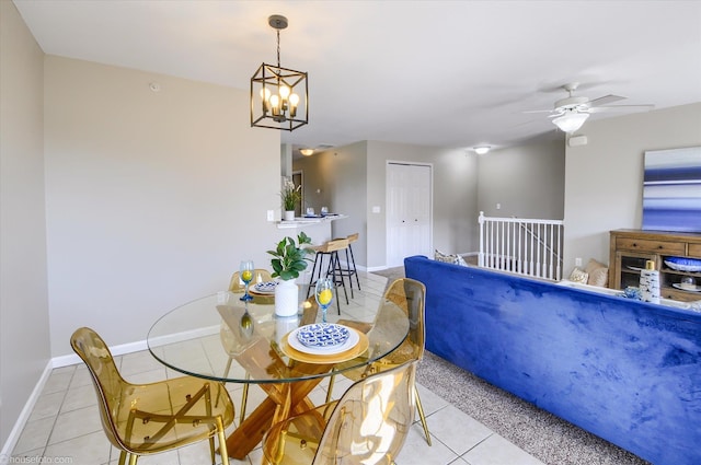 dining space featuring ceiling fan with notable chandelier, baseboards, and light tile patterned floors
