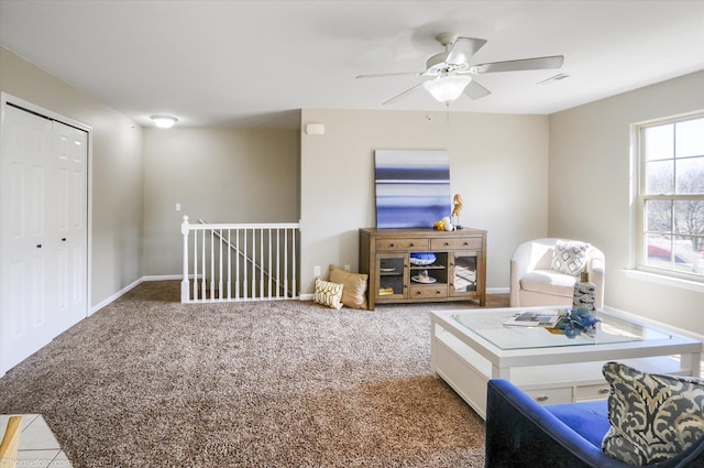 sitting room featuring an upstairs landing, carpet flooring, baseboards, visible vents, and ceiling fan