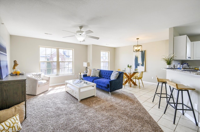 living area featuring baseboards, visible vents, ceiling fan, and light tile patterned floors