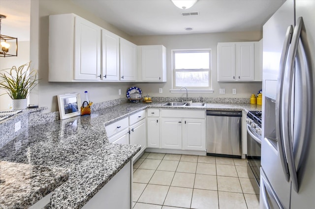 kitchen featuring white cabinetry, light tile patterned floors, a sink, visible vents, and appliances with stainless steel finishes