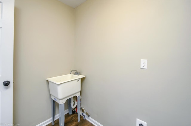 washroom with baseboards, laundry area, dark wood-type flooring, and electric dryer hookup