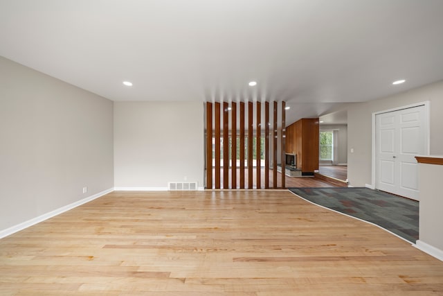 spare room with wood finished floors, recessed lighting, baseboards, and visible vents