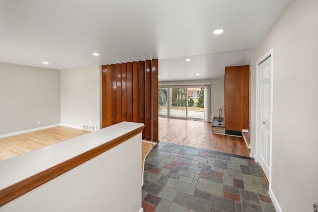 hallway featuring recessed lighting, dark wood-type flooring, baseboards, and visible vents