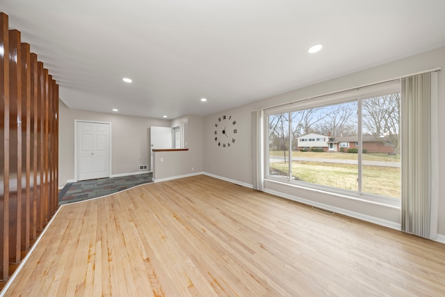 empty room featuring recessed lighting, baseboards, visible vents, and wood finished floors